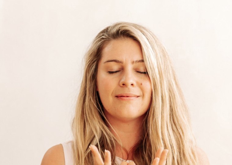 Alexandria with her eyes closed and hands together in meditation
